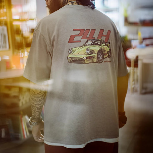 Person wearing a t-shirt with a car graphic and '24H' text on the back.
